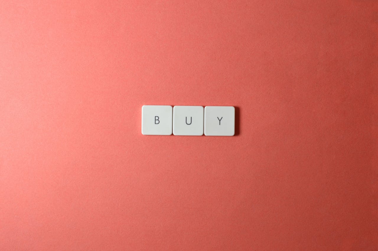 Keyboard keys spelling BUY on a coral background, ideal for e-commerce themes.