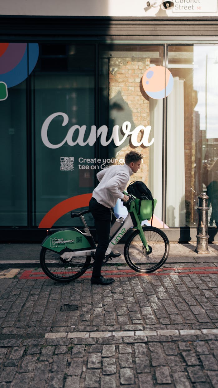 services-img Cyclist rides rental bike past a trendy Canva storefront on city street.